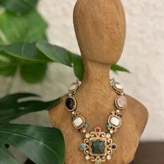 Crafted to turn moments into memories. This navratna-style necklace features a beautiful array of semi-precious stones set in an ornate gold design.