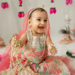 A happy little Radha playing with pearl necklaces. I let babies play and interact with props to capture their natural curiosity and joyful expressions.