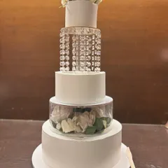 For a touch of pure luxury, this four-tier eggless wedding cake is an absolute showstopper. It features a tier of cascading crystals that sparkle like a chandelier, and another filled with fresh white roses, creating a truly glamorous look.