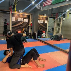 A glimpse into our Friday morning grappling session. Students are practicing ground control and submission techniques, a critical component of MMA and self-defense.