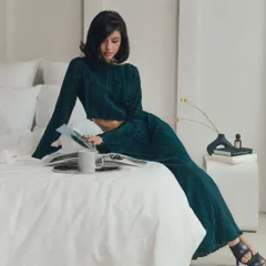 A lifestyle shot of the pleated two-piece set. It's versatile enough to be worn for a relaxed event or dressed up for a more formal occasion.