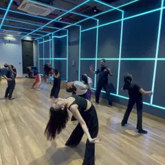 A group of students in my contemporary class practicing a fluid backbend movement in our neon-lit studio.