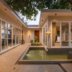 The Amberle resort courtyard transforms at dusk. The combination of underwater lights in the pool and warm sconces on the walls creates a serene and magical atmosphere.