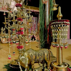 A sacred corner designed for a sunrise wedding, featuring an array of traditional brass lamps (diyas), a beautifully detailed Kamadhenu statue, and pearl-studded hangings. Every element was chosen to evoke the sanctity of a South Indian temple ceremony.