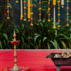 Simple details can create a powerful atmosphere. A traditional brass lamp, or 'diya', placed on a bed of flower petals adds a warm and sacred glow to any Indian wedding ceremony.