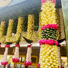 The beauty of traditional decor is in the details. Here you can see 'thomala' hangings made from woven leaves and fresh flowers, a classic element we teach you to create.