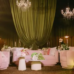 A chic and playful lounge setup for the "Big Bow Affair." I used modern pink sofas and armchairs, complemented by elegant chandeliers and soft green draping, to create a space that felt both stylish and inviting.