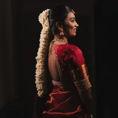 A stunning profile shot of my bride Dishaa, her traditional braid and red Kanjeevaram saree creating a timeless silhouette.