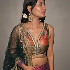 For Diwali, I designed this custom lehenga, upcycling my mom's old saree for the blouse. The look features a rich magenta skirt and a brocade top, finished with fresh flowers in my hair.
