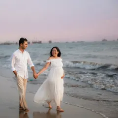 A happy stroll along the shoreline. Outdoor sessions allow for natural, candid moments like this, capturing the love and excitement between a couple against the beautiful Mumbai coast.