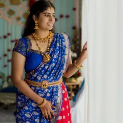 A portrait of a beautiful bride in a traditional South Indian half saree, looking out a window in anticipation. We capture the quiet moments that are rich with cultural heritage.