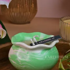 A beautiful marbled green and white Jesmonite candle pot, with a delicate, ruffled edge. Each one has a unique pattern.