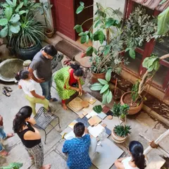 Our design process is hands-on. Here, we are in our studio courtyard with clients, arranging a physical mood board with real samples of stone, wood, and plants to define the project's material palette.