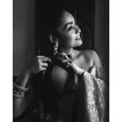 A moody and artistic black and white portrait. The use of natural light and shadow creates a timeless image that feels like a scene from a classic film.