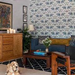 A cozy, lived-in moment in the Boho-Desi lounge. The space is designed to be welcoming for all family members, with a comfortable sofa, eclectic decor, and a charming cocker spaniel enjoying the room.