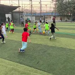 It's game time at the birthday bash! A mini-football match is in full swing, with kids of all ages chasing the ball and having a blast on the turf.