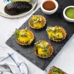 A modern twist on a classic street food. These crisp phyllo cups are filled with a creamy avocado mousse chaat, offering a surprising burst of zesty and savory flavors in a single, elegant bite.