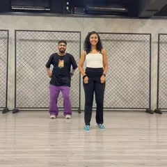 Posing with a dance partner in the studio. The industrial-style background with mesh panels is a space where so much creativity happens.