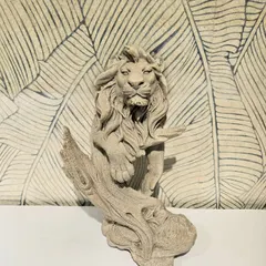 This majestic lion sculpture with a stone finish appears to emerge from a branch. It's a unique and artistic piece that symbolizes strength and courage.