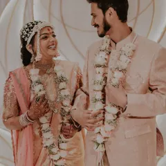 A candid, joyful moment between the couple, with their beautiful floral varmalas.