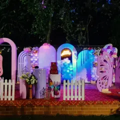 This butterfly-themed birthday setup looks especially magical at night. The glowing arches and large, pink butterfly wings create a beautiful photo backdrop for an evening celebration.