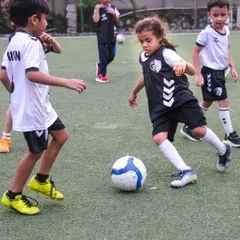 A young player skillfully navigates the ball during a practice game. We foster a dynamic environment where even our U8 players learn to think on their feet and play as a team.