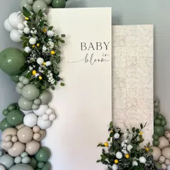 A "Baby in Bloom" theme with a refreshing green and white color palette. The design incorporates a balloon garland with pops of lemon and delicate flowers for a natural, organic feel.