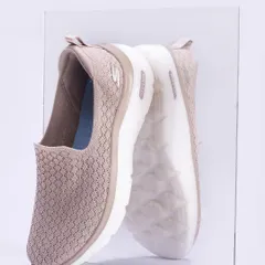 A side-profile shot of a Skechers Go Walk shoe pressed against a sheet of glass, showing its reflection. This angle highlights the shoe's silhouette and sole design, offering a unique and detailed perspective.