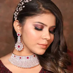 Add a touch of color with this beautiful diamond-look choker with ruby-red stones. Paired with matching drop earrings and a hair accessory, it's a complete rental set for any party.