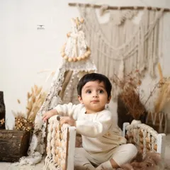 This baby boy looks so sweet and curious sitting in a miniature beaded bed. Sitter sessions are perfect for capturing this inquisitive stage.