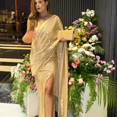 Dressed in a shimmering gold saree, ready for a glamorous evening.