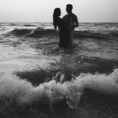 A dramatic black and white seascape from an engagement session. Standing together against the vastness of the ocean creates a powerful, moody photograph that feels both epic and deeply personal.