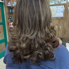 A classic layered cut enhanced with subtle caramel and blonde highlights. This technique adds dimension and movement to the hair, making it look fuller and more dynamic.