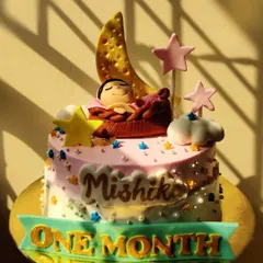 Celebrating baby Mishika's very first month! This sweet cake features a tiny baby sleeping on a crescent moon, surrounded by stars. First milestones are always so special.