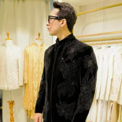A full view of the black velvet jacket, showing how the intricate tonal floral embroidery covers the sleeves and body, creating a rich, textured, and luxurious garment.
