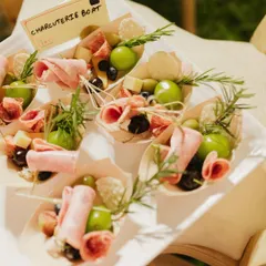Perfect for mingling, my individual charcuterie boats are a guest favorite. Each boat is a personal treasure of cured meats, fresh grapes, olives, and cheese, garnished with rosemary. It's a sophisticated and convenient way to enjoy gourmet bites.