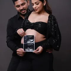 A slightly different angle of the couple sharing their sonogram. This pose captures their happy expressions as they look down at the first pictures of their baby.