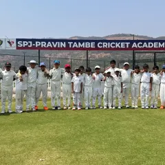 A wide shot of our players assembled on the lush green field, with the official academy banner in the background. This is where future stars are made.