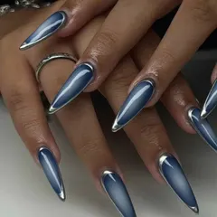 This unique "denim" effect is created with a blue cat-eye polish and a silver chrome border on long stiletto nails.