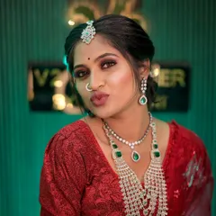 A playful and confident shot of the bride in her red reception outfit. The puff-sleeve blouse adds a touch of modern trendiness, while the magnificent layered diamond necklace ensures the look remains timelessly elegant.