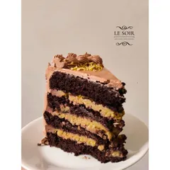 A slice of my viral Pistachio Kunafa Chocolate Cake. This special treat, made only for bakesales, has layers of chocolate cake and crunchy pistachio kunafa filling.
