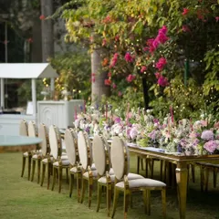 The seating arrangement for a formal corporate dinner. The combination of plush chairs, a reflective tabletop, and a dense floral centerpiece creates an atmosphere of refined elegance for guests.
