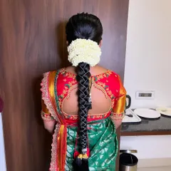 A detailed view of the traditional braided hairstyle for Prathiba's Seemantham, complete with fresh jasmine flowers for a classic South Indian touch.