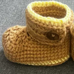 A close-up of my adjustable baby booties in a warm brown and yellow. They are soft, warm, and perfect for tiny feet.