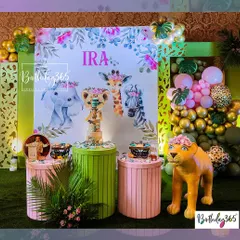 We transformed this space into a chic jungle for Ira's first birthday. The setup featured a watercolor-style animal backdrop, life-sized lion prop, and a mix of pink, green, and gold decor.
