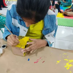 A young artist painting a project during a group art session. We hosted kids and moms who came all the way from Tumkur!