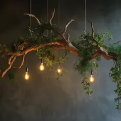 A dramatic and artistic green chandelier made from a natural tree branch, intertwined with foliage and illuminated by warm Edison bulbs. This piece is perfect for creating a moody, enchanting atmosphere.