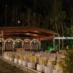 This wide view shows a complete outdoor stage and seating arrangement we prepared for an evening corporate event. We manage the entire setup, including chair dressing, ambient lighting in the surrounding trees, and the main stage backdrop.