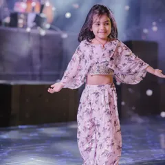 An adorable little girl in a beautiful outfit, ready for her moment in the spotlight. Her grace and smile are what make kids' performances so special.