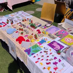 An overhead view of my market stall, showcasing the wide variety of my work. You can see the spread of my handmade crochet items alongside my art prints and sticker sheets, giving a full picture of my creative range.